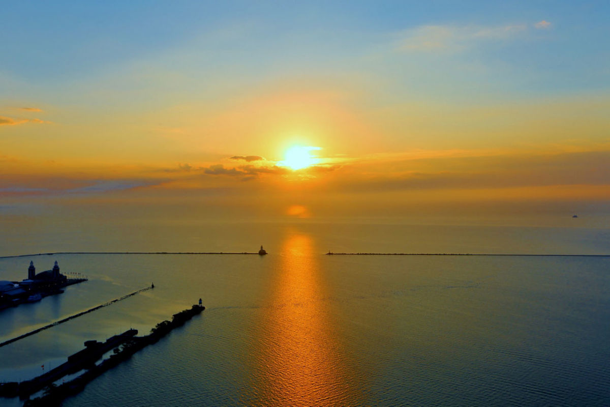 Scenic view of sea against dramatic sky during sunset