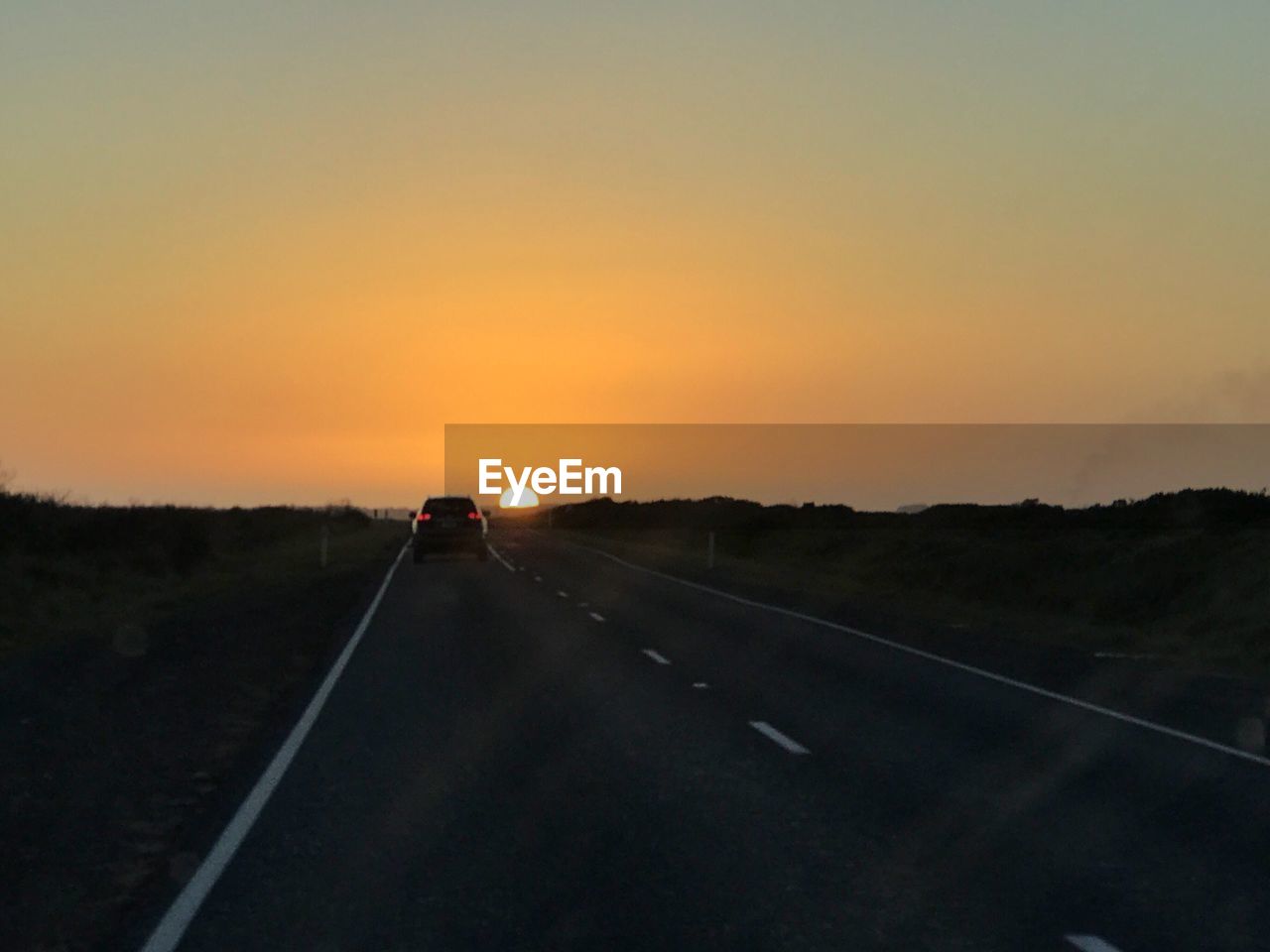 ROAD AMIDST LANDSCAPE AGAINST SKY DURING SUNSET