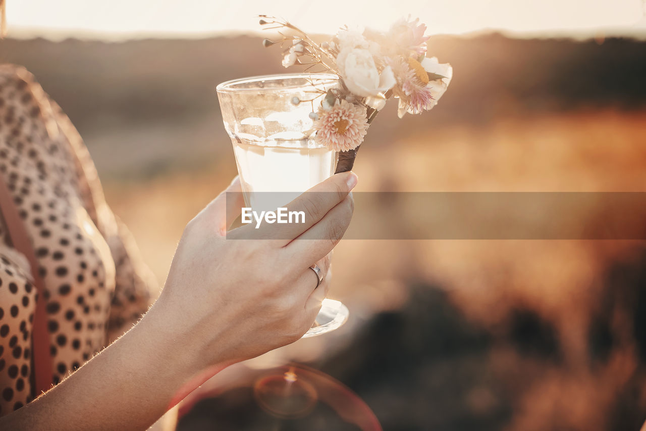 Midsection of woman holding drink outdoors