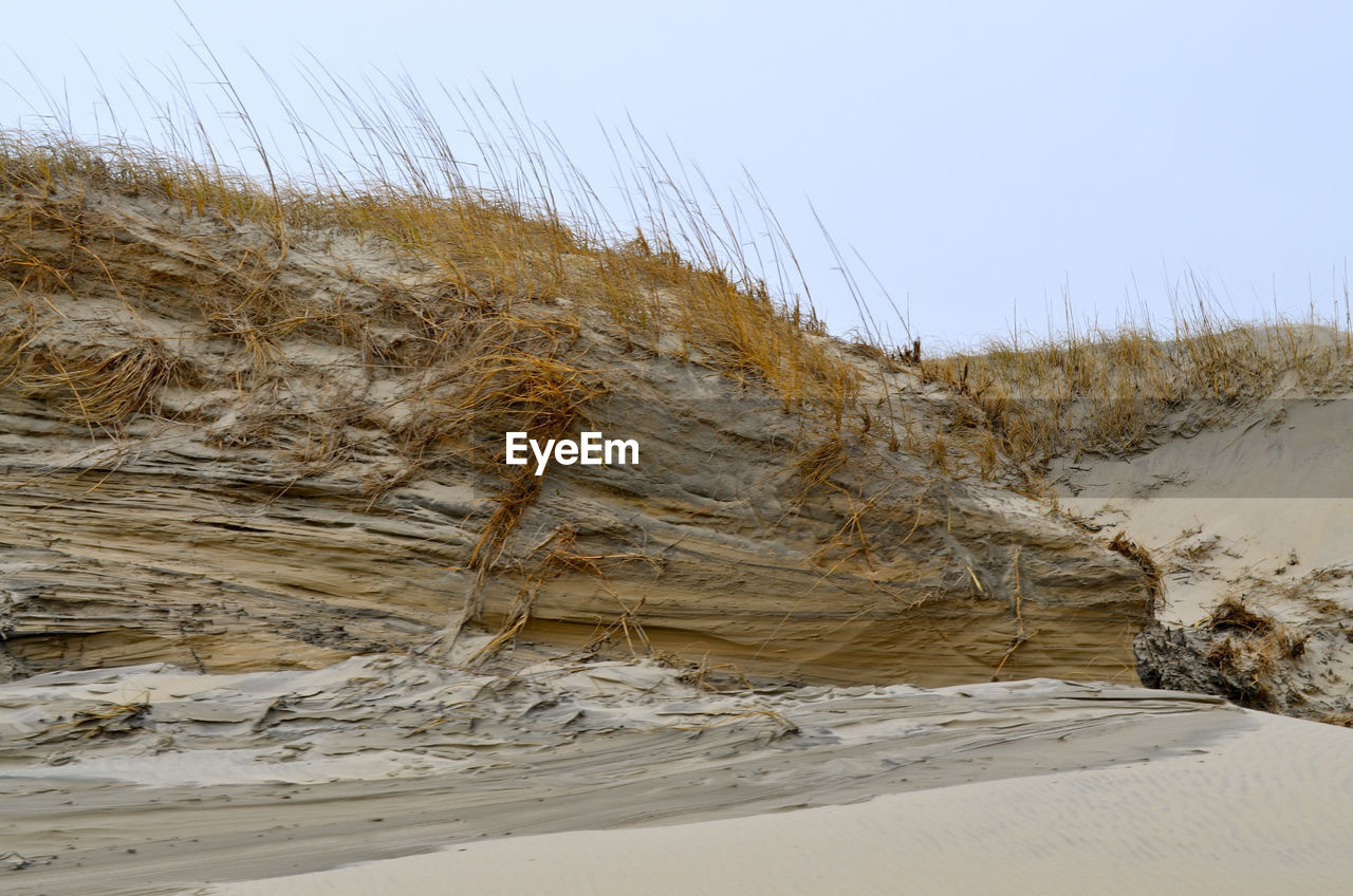 Scenic view of sand dunes against clear sky