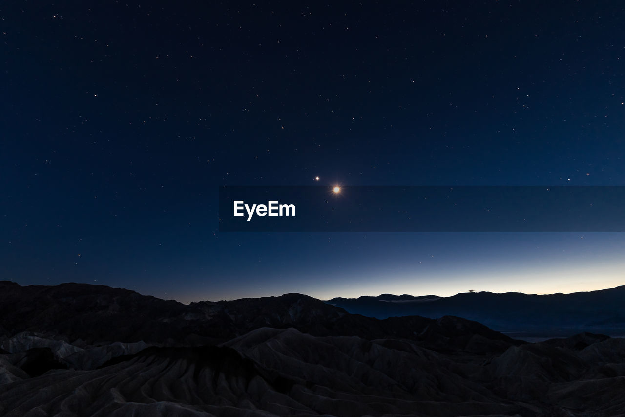 Scenic view of mountains against clear sky at night