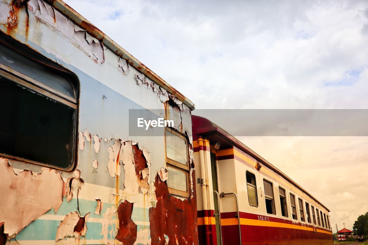 LOW ANGLE VIEW OF TRAIN BY WINDOW AGAINST SKY