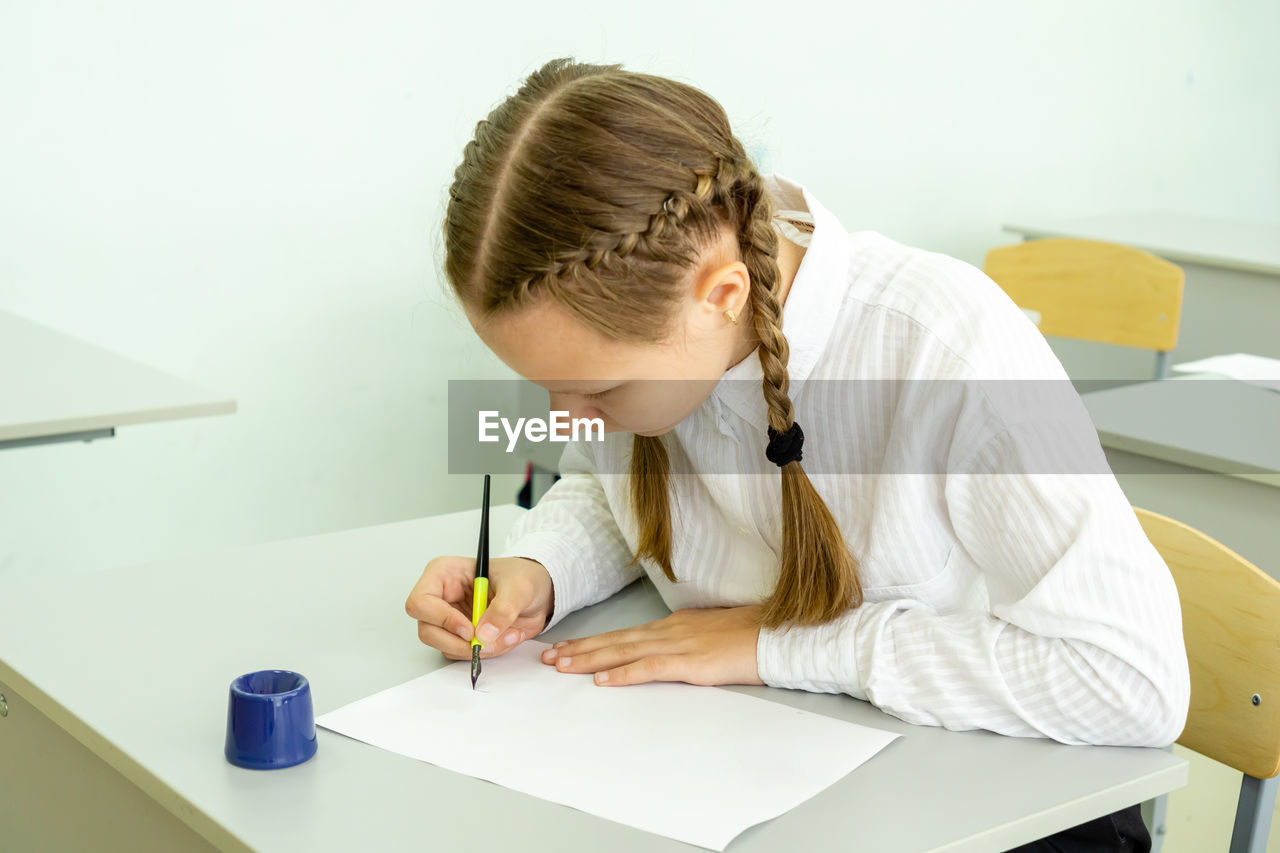 Girl drawing on paper at school