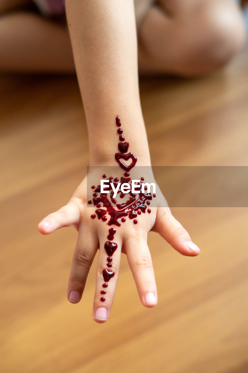 Henna ornaments on little girl's hand closeup.