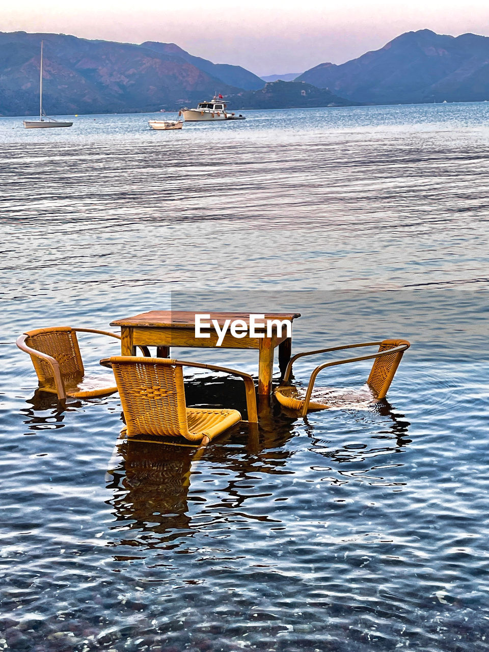 water, mountain, shore, sea, nature, tranquility, no people, scenics - nature, beauty in nature, transportation, tranquil scene, nautical vessel, environment, sky, bay, day, outdoors, travel, land, travel destinations, boat, wood, vehicle, beach, seat, landscape, chair, relaxation, coast, boating, reflection, mode of transportation, ocean, absence, mountain range