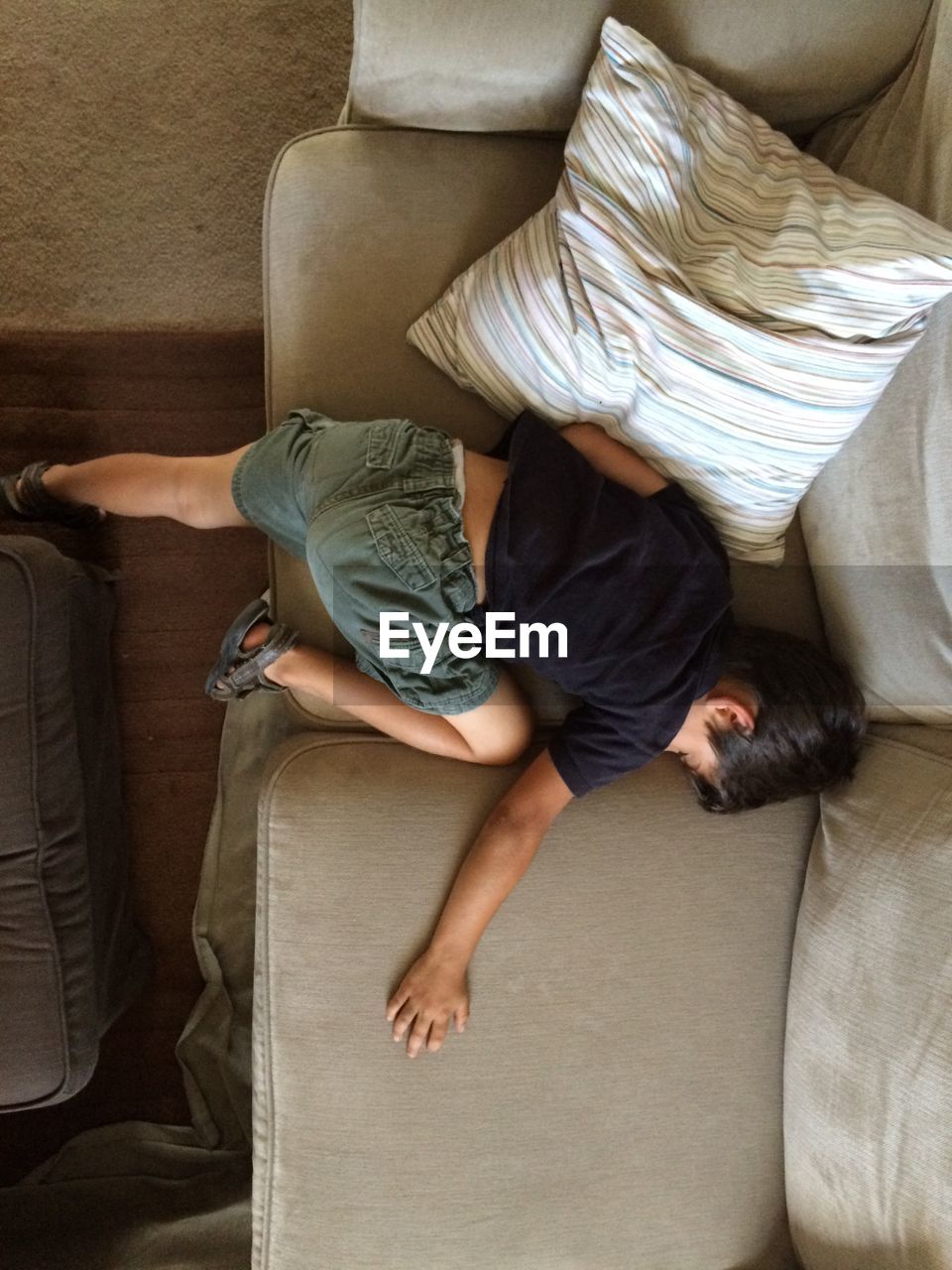 Directly above view of boy sleeping on sofa at home