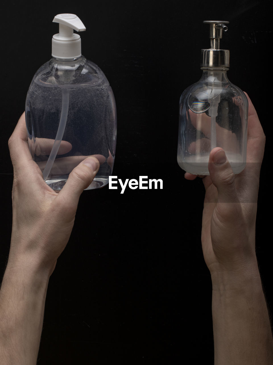 MIDSECTION OF PERSON HOLDING GLASS BOTTLE