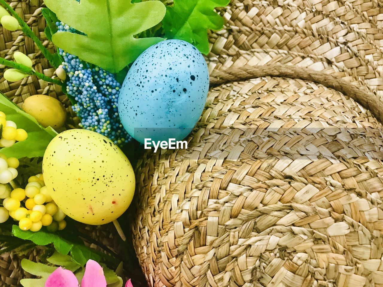 HIGH ANGLE VIEW OF MULTI COLORED EGGS IN WICKER BASKET