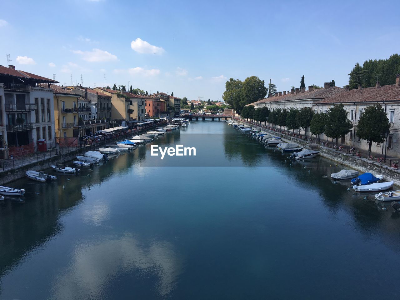 Canal amidst buildings in city against sky