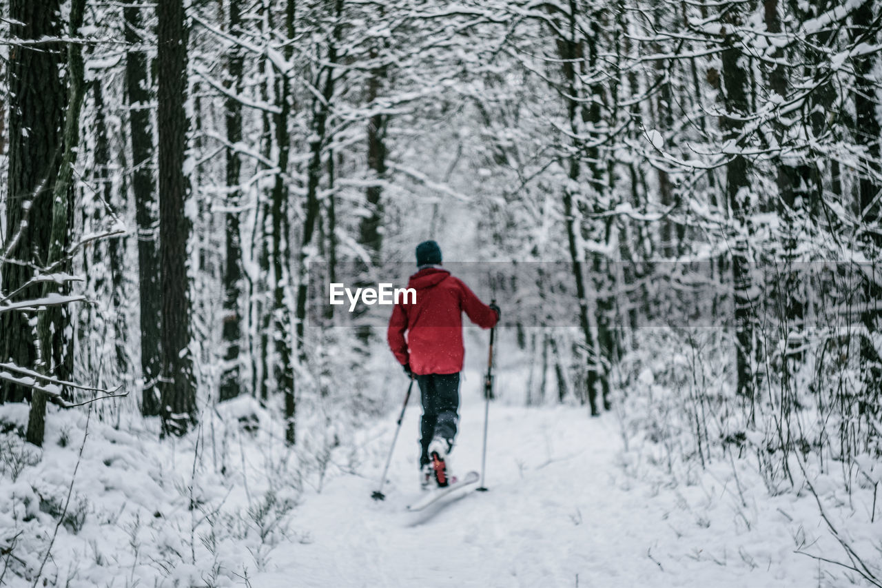 REAR VIEW OF PERSON IN SNOW DURING WINTER