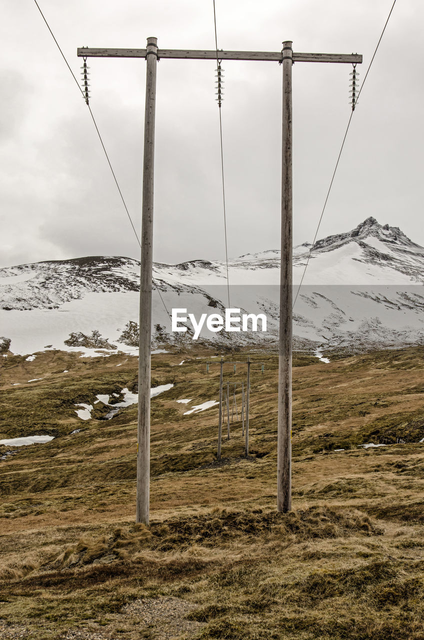 Wooden electricity poles with power lines in a mountain landscape 