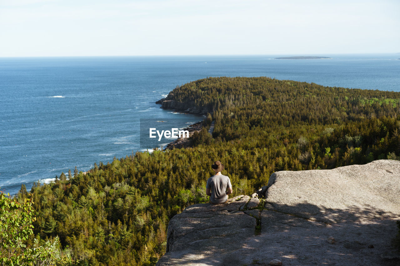 Man viewing otter cliff from gorham mountain, acadia national park, maine, usa