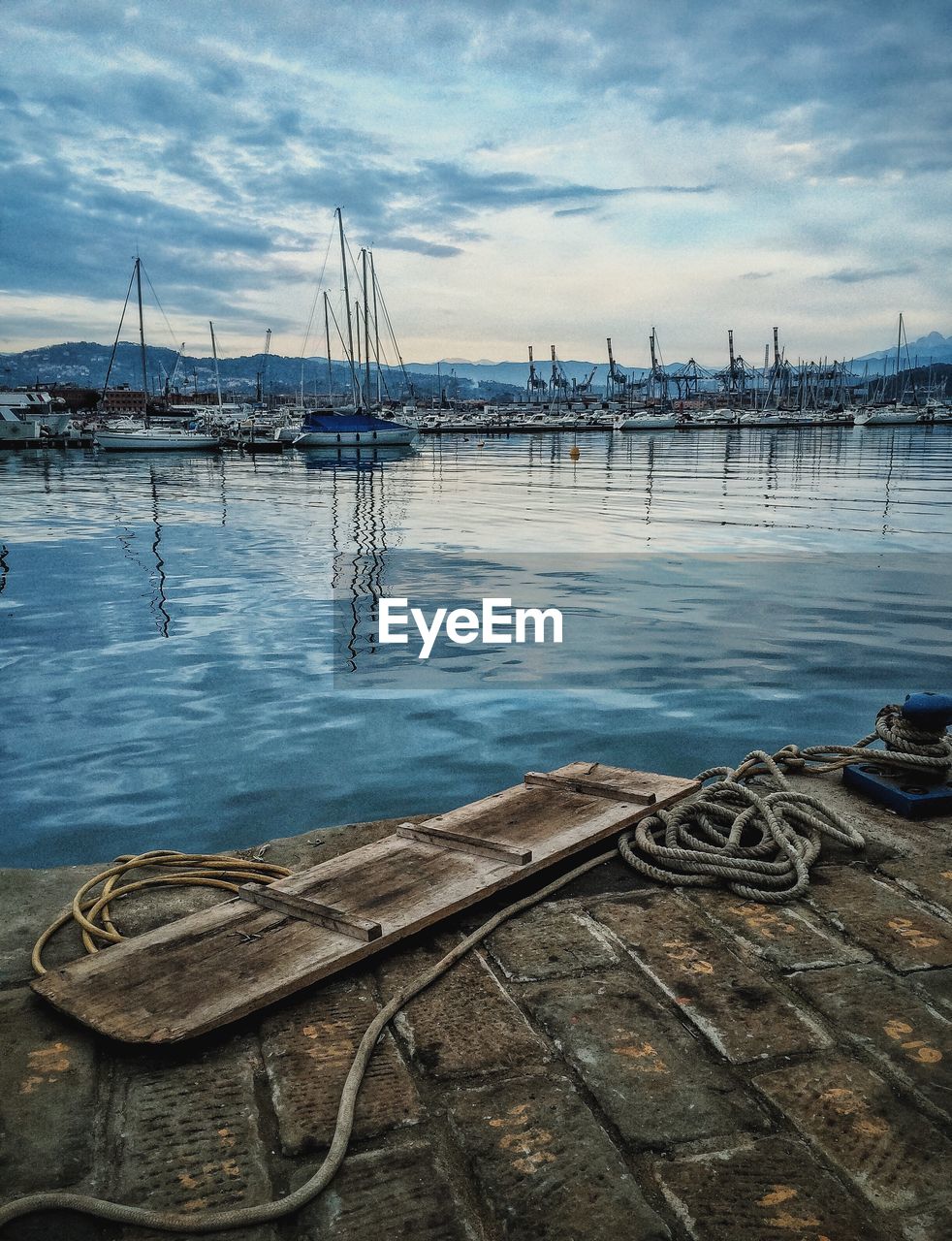 Moored rope at harbor against sky