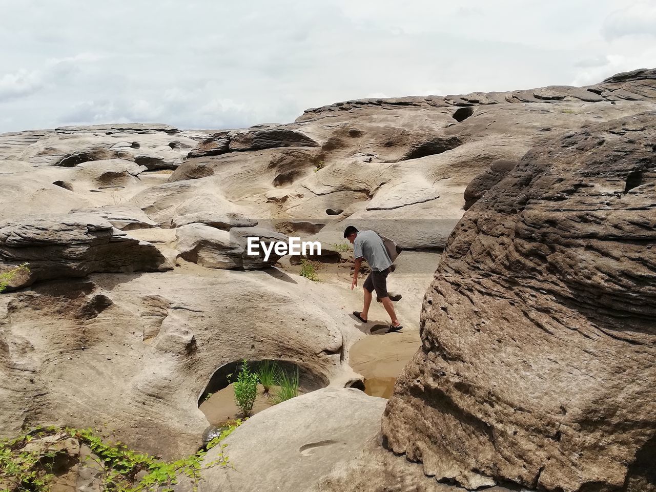 Full length of man walking on rocks against sky