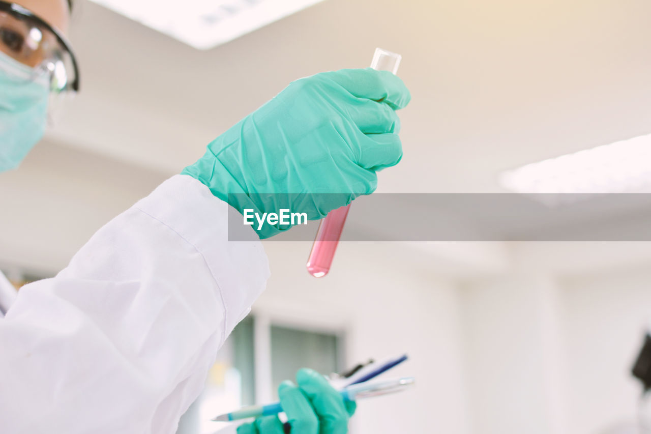 Cropped image of female scientist holding test tube at laboratory