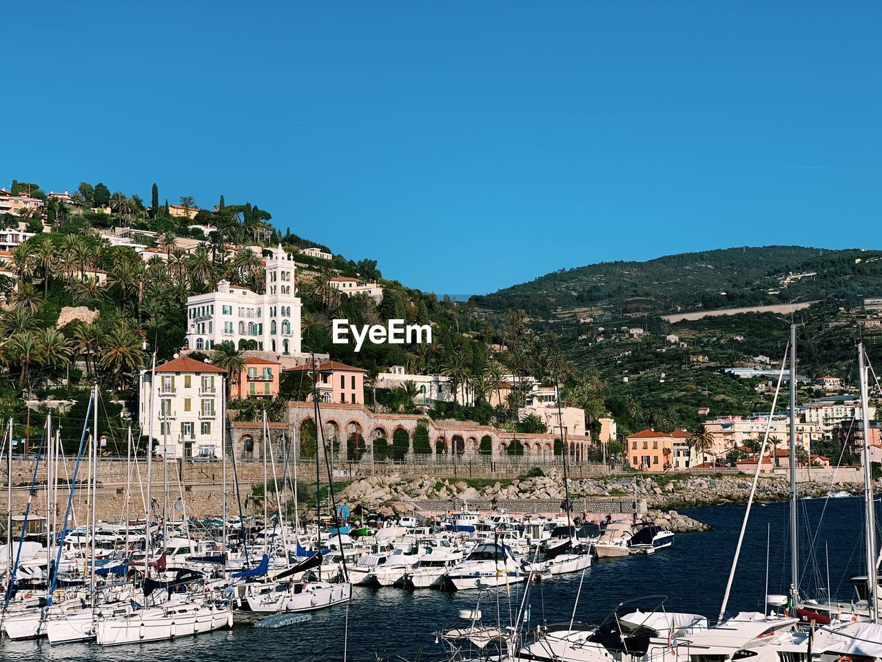 Boats moored in harbor against buildings in city