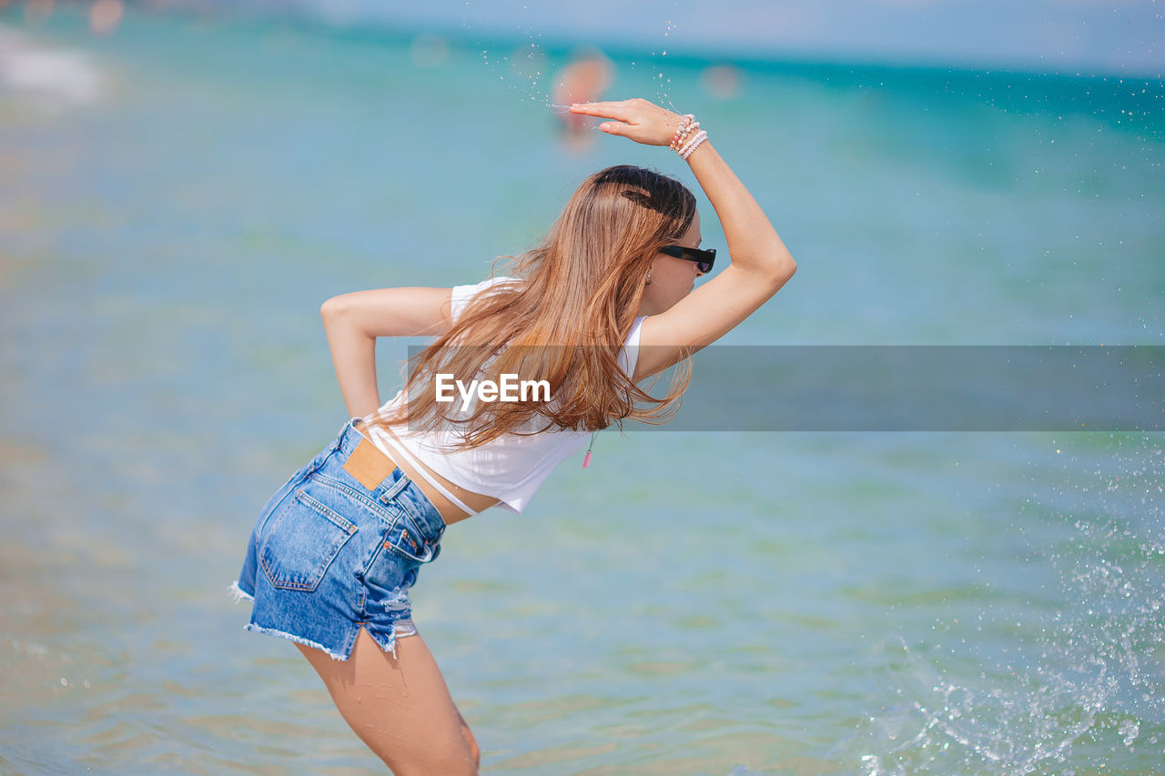 rear view of young woman standing in swimming pool