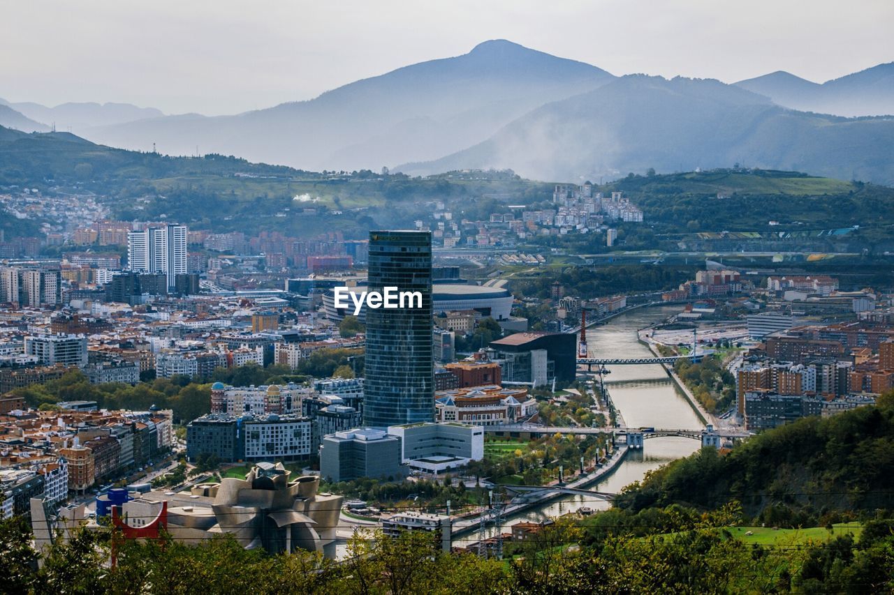 City by mountains against sky