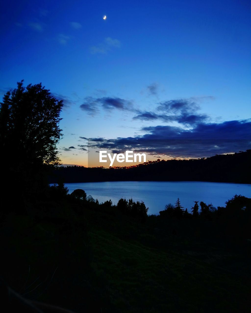 SCENIC VIEW OF LAKE BY SILHOUETTE TREES AGAINST SKY