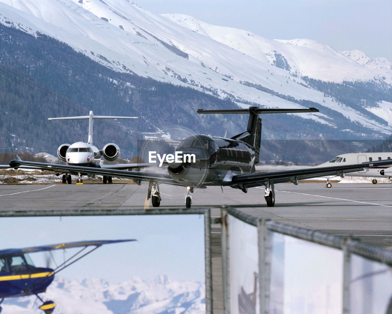 Airplane flying against snow covered mountains against sky