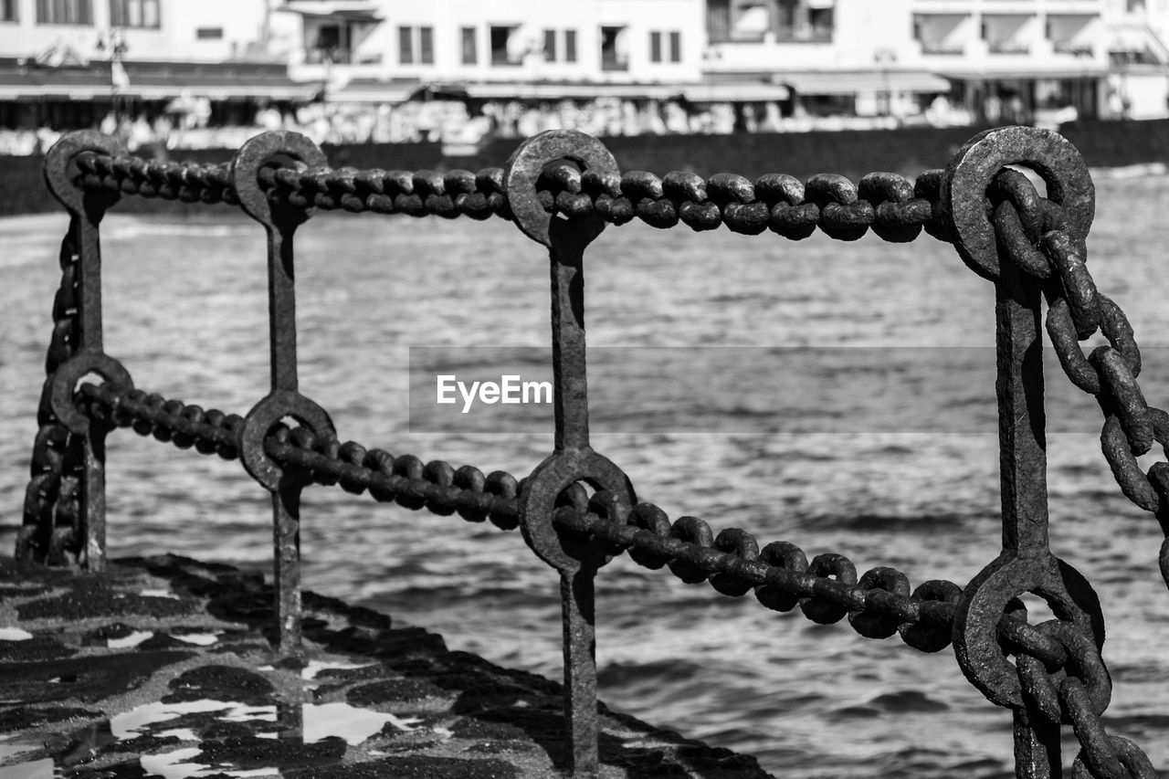 CLOSE-UP OF CHAIN AND ROPE ON SEA