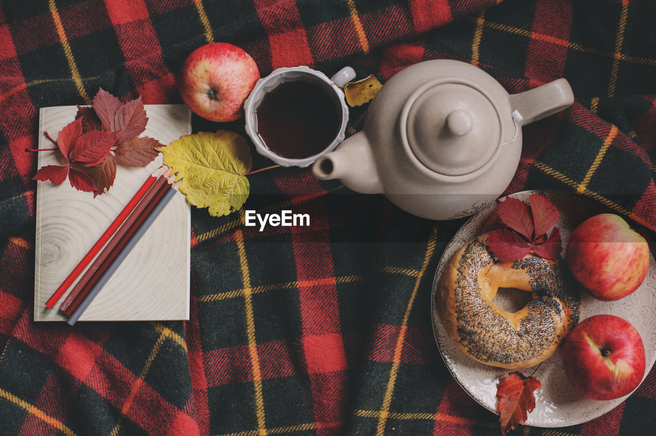 Directly above shot of breakfast with pencils and paper on bed