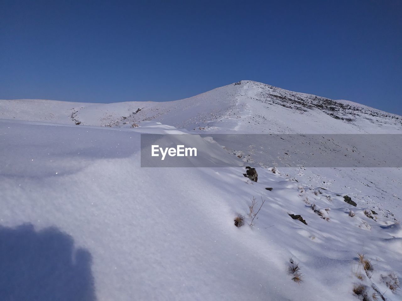 SCENIC VIEW OF SNOW COVERED LANDSCAPE AGAINST BLUE SKY
