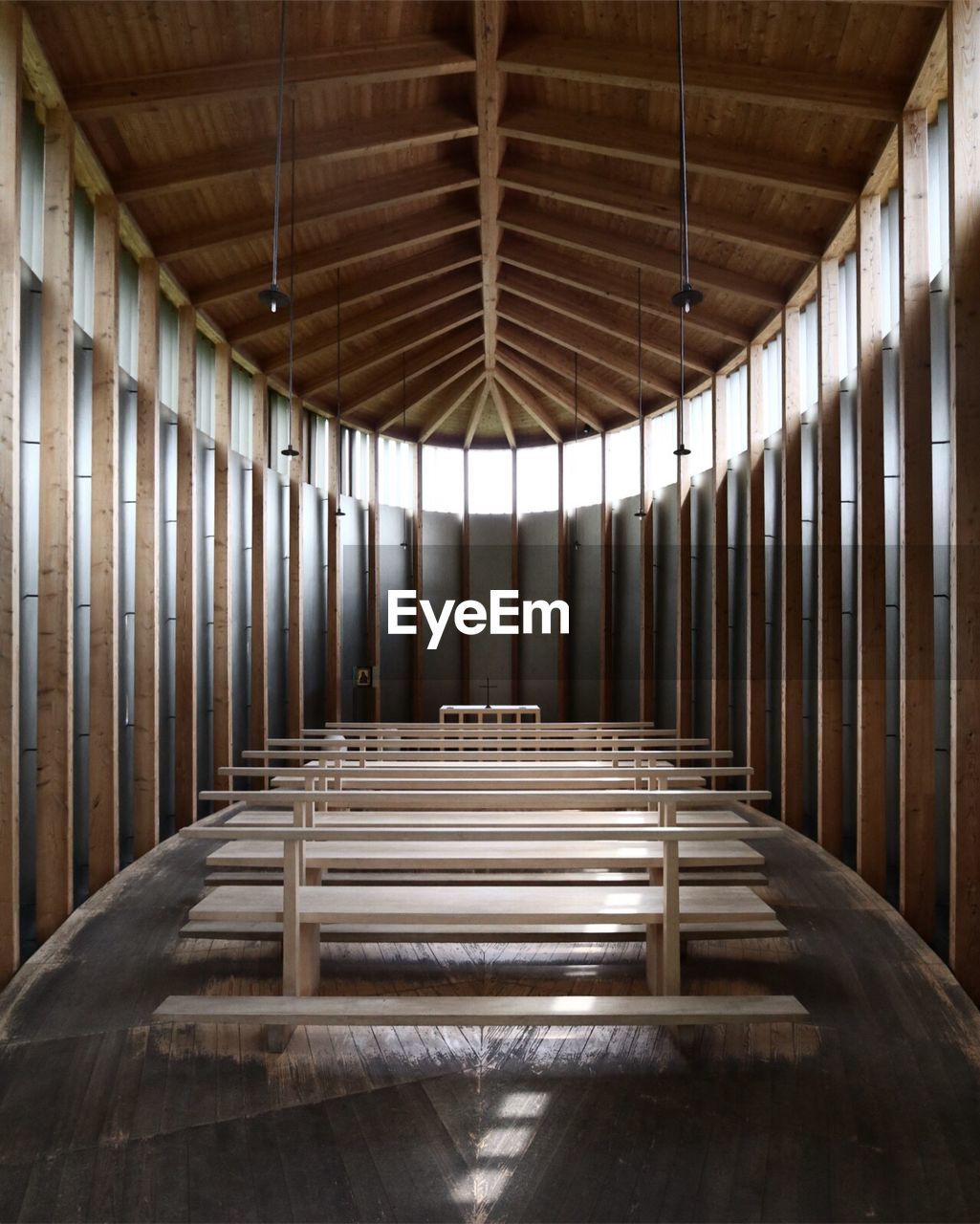 Wooden benches below roof beam in church