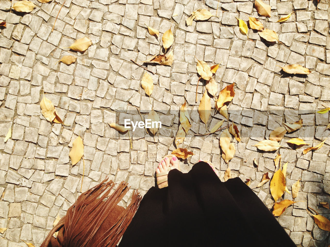 Low section of woman standing on footpath