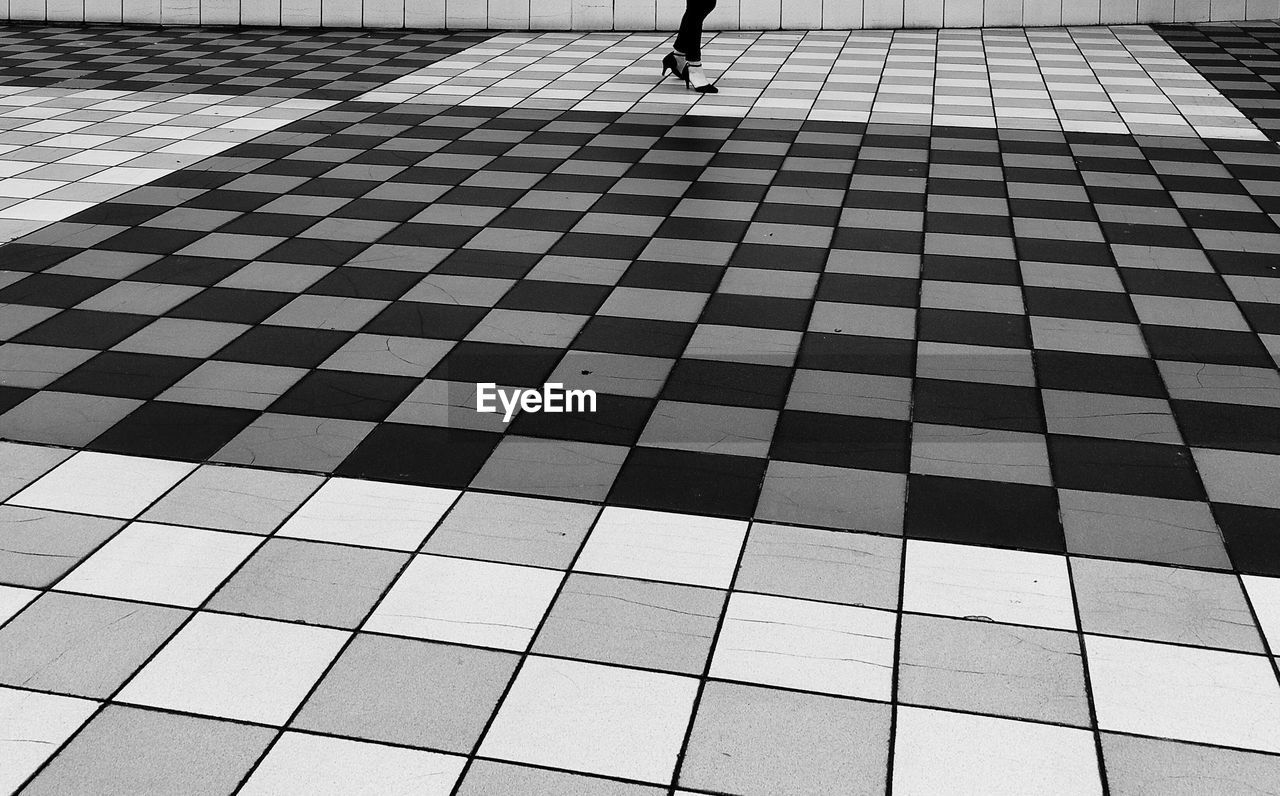 Low section of woman walking on tiled floor