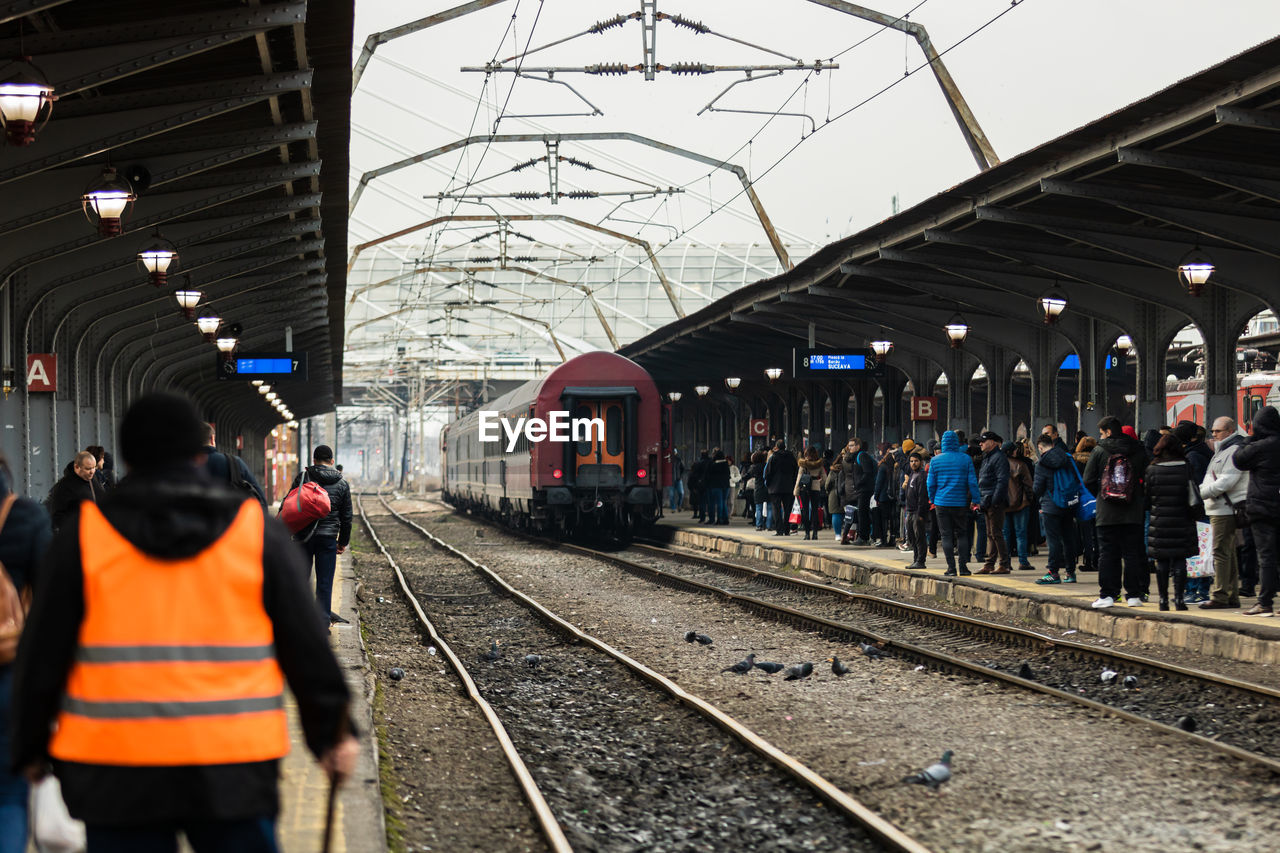 PEOPLE WAITING AT RAILROAD STATION PLATFORM