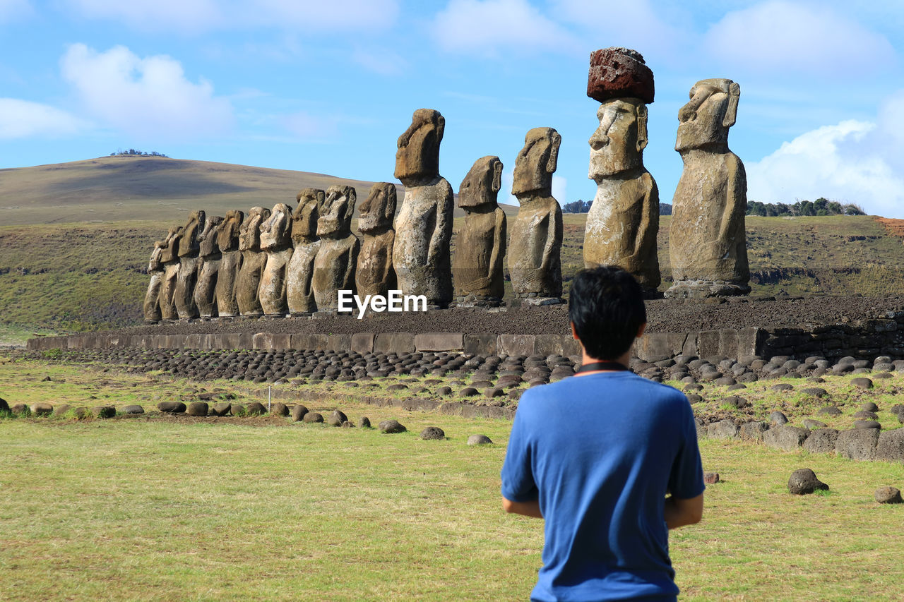 Rear view of man standing against rock formation