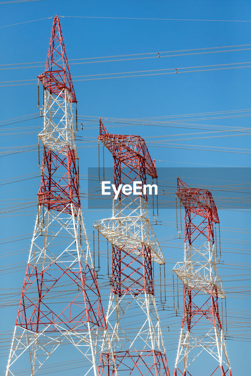 LOW ANGLE VIEW OF ELECTRICITY PYLON AGAINST CLEAR BLUE SKY