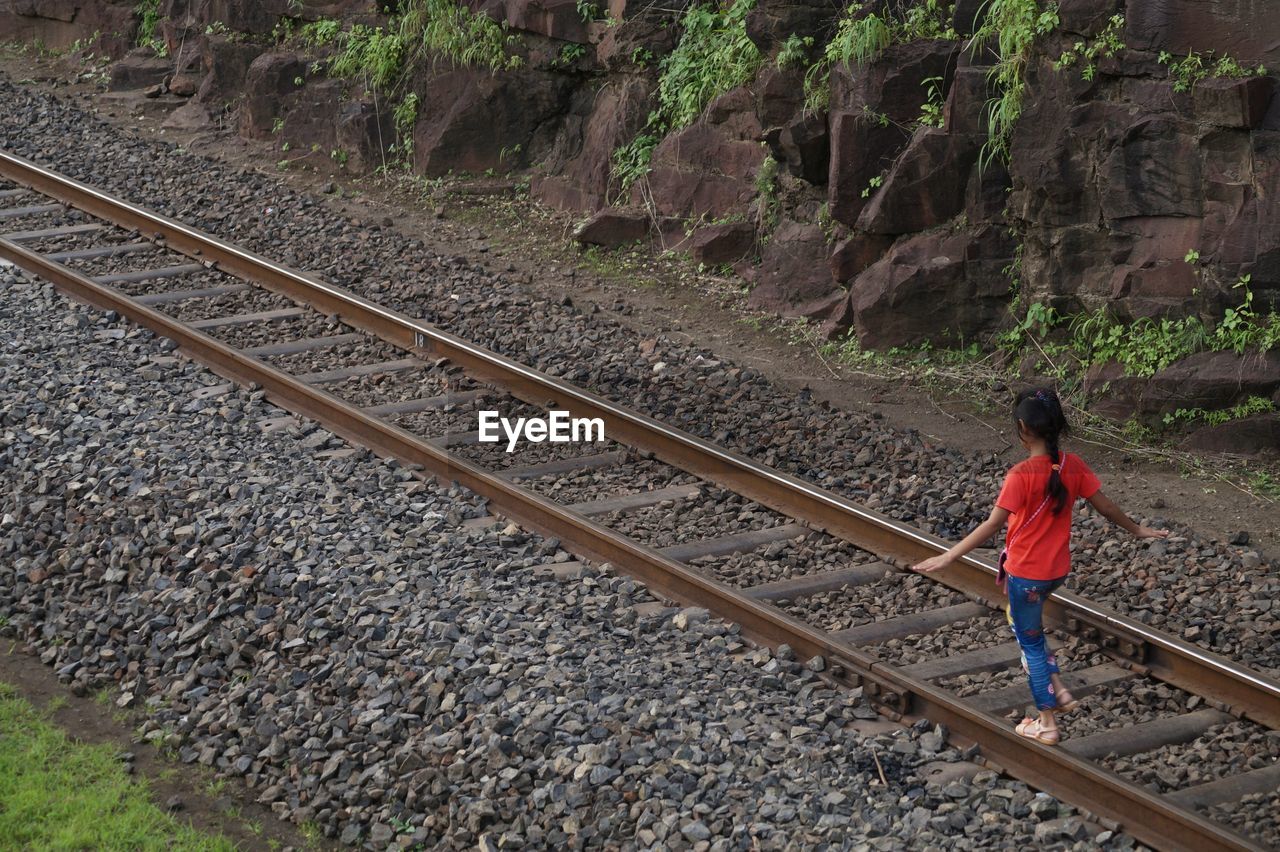 High angle view of girl walking on railroad track