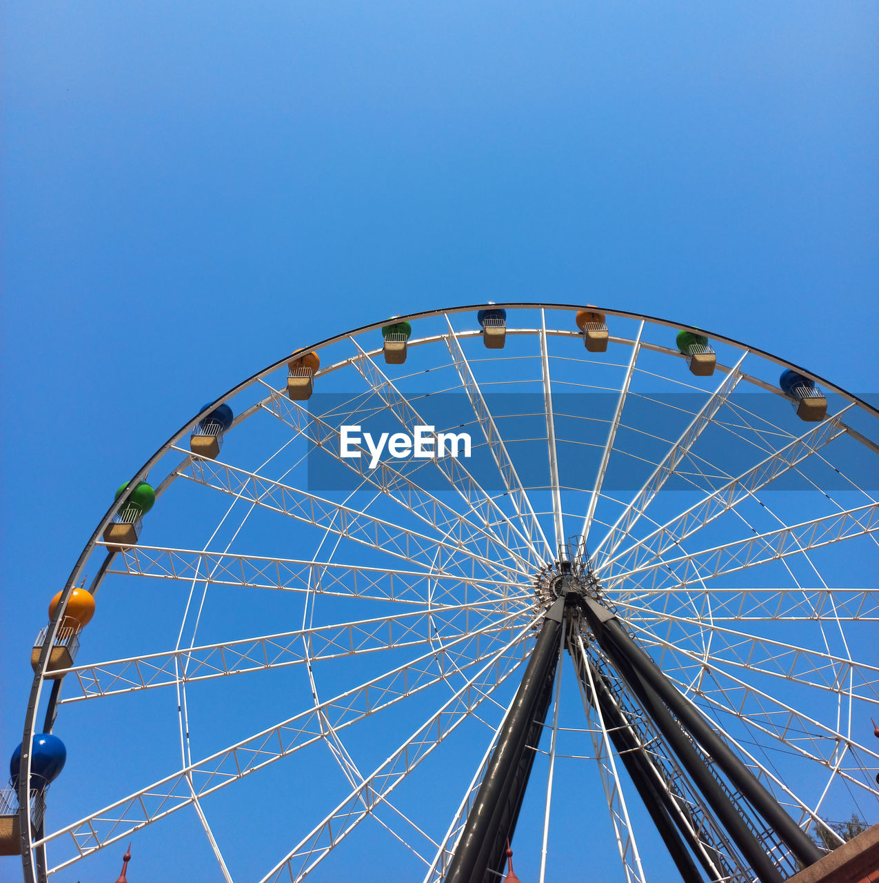 low angle view of ferris wheel against clear blue sky