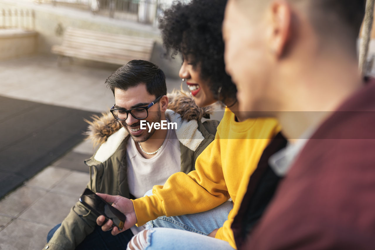 High angle view of woman using phone by friends