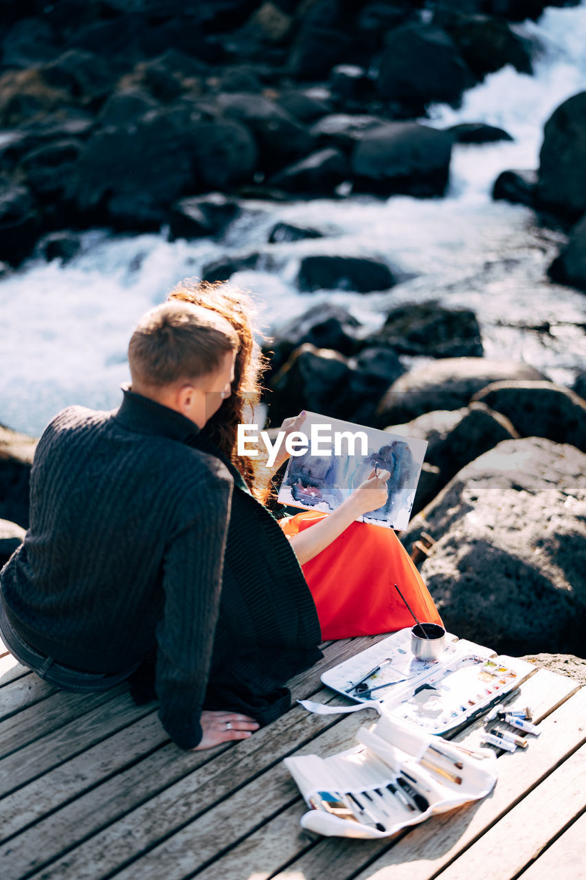 Man and woman sitting on pier