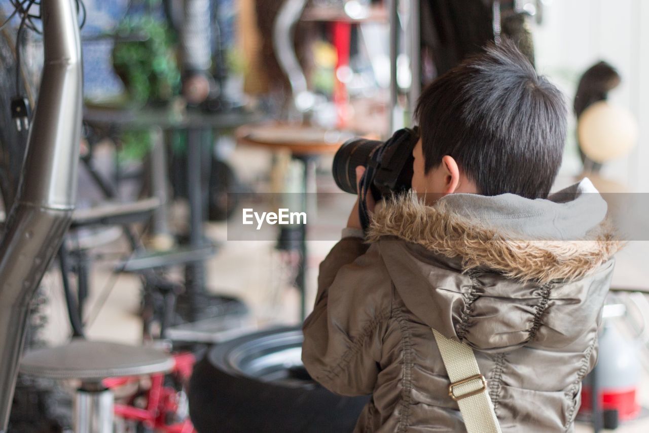 Rear view of boy photographing