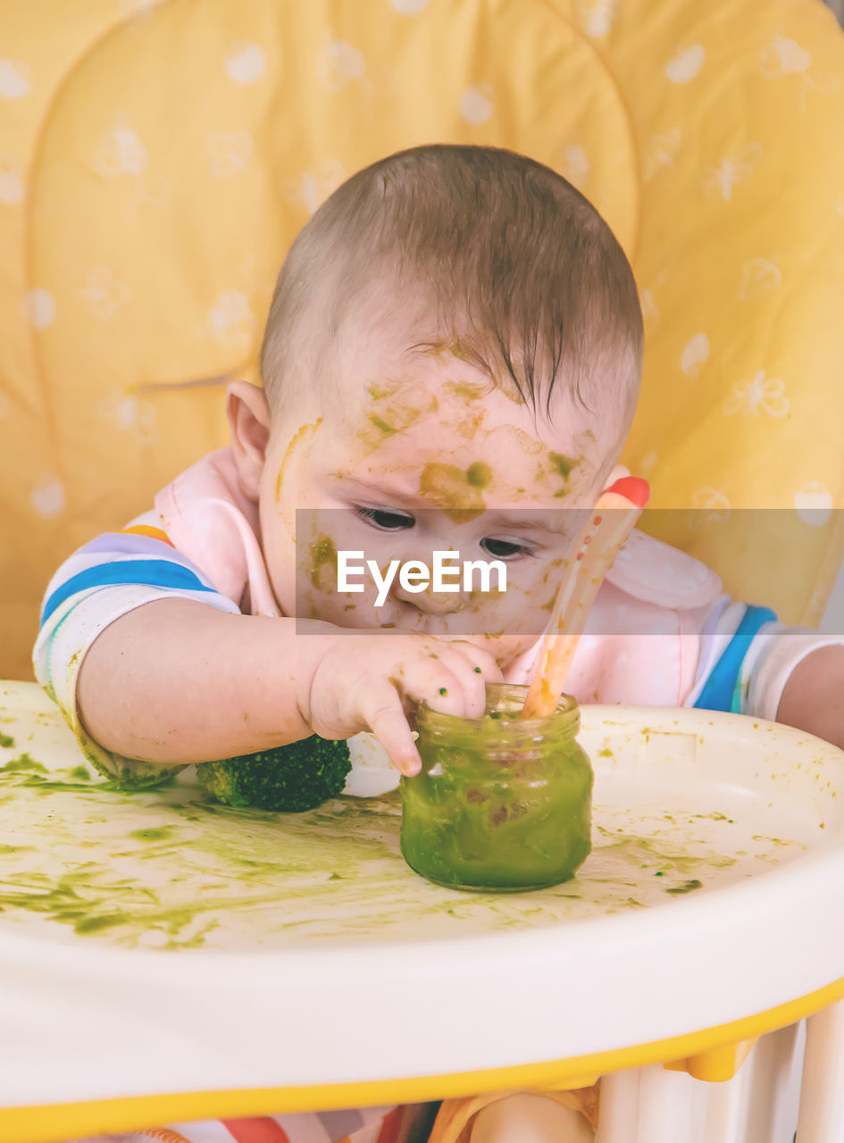 high angle view of cute baby boy eating food at home