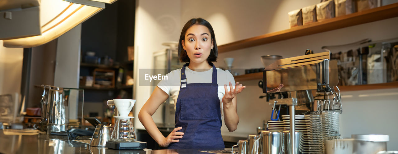 portrait of young woman standing at table