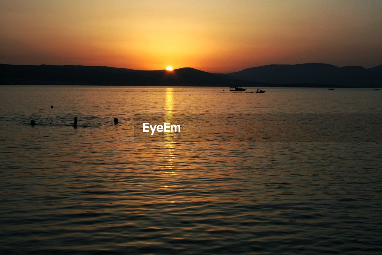 SILHOUETTE OF A LAKE AT SUNSET