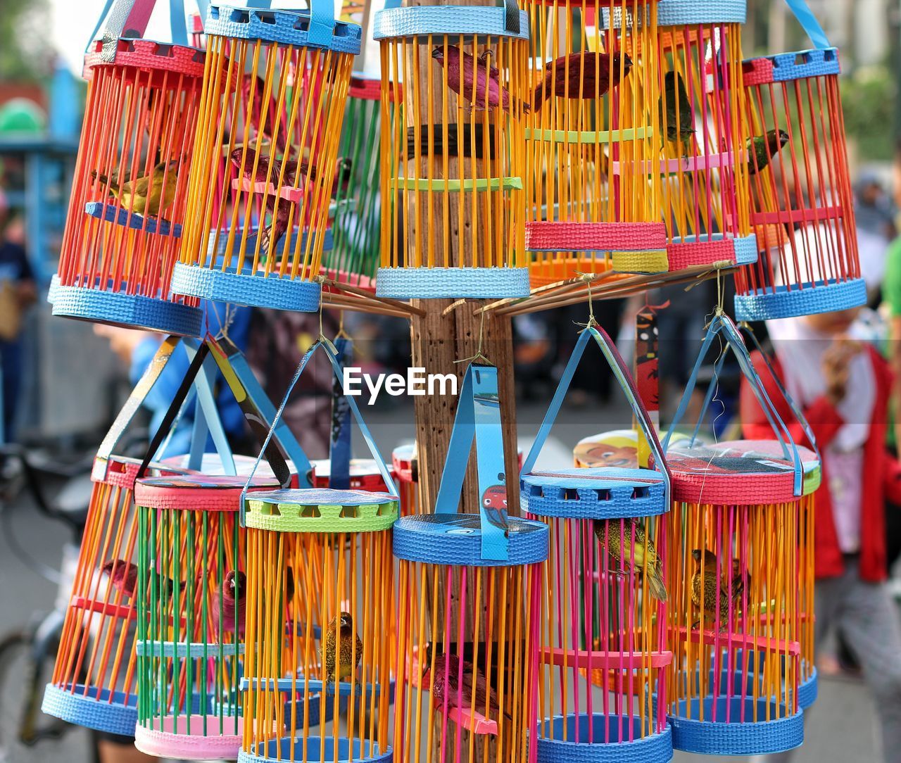 Close-up of multi colored cage for sale at market stall