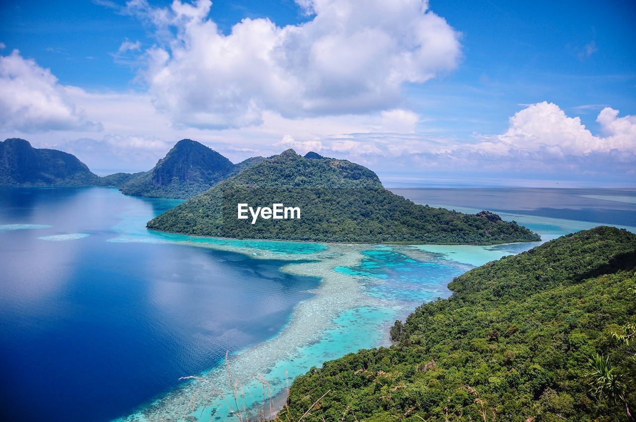 Scenic view of sea and mountains against sky