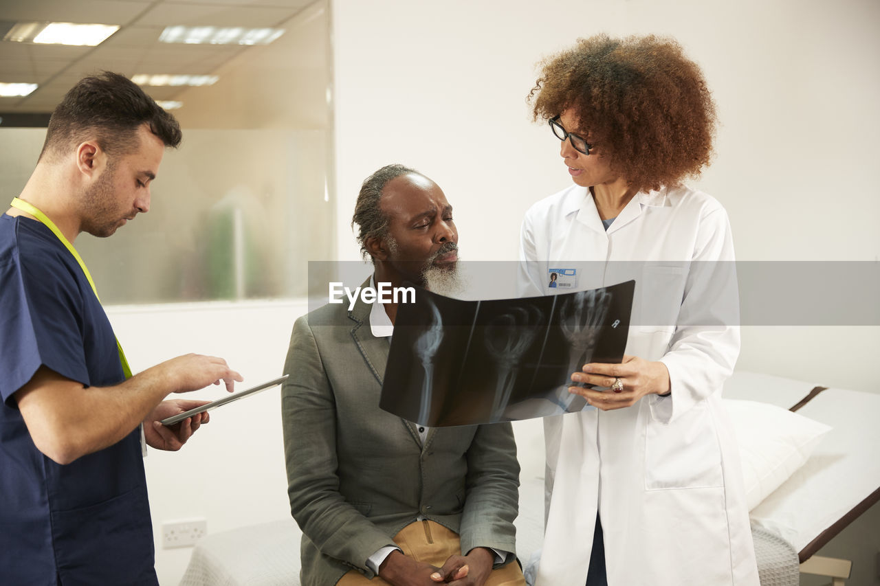 Doctor discussing x-ray report with patient in medical room