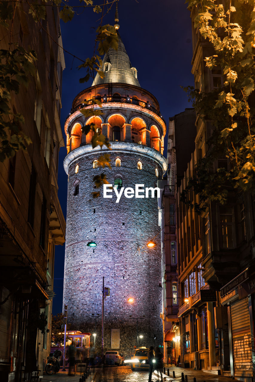 Low angle view of illuminated tower in old town - galata