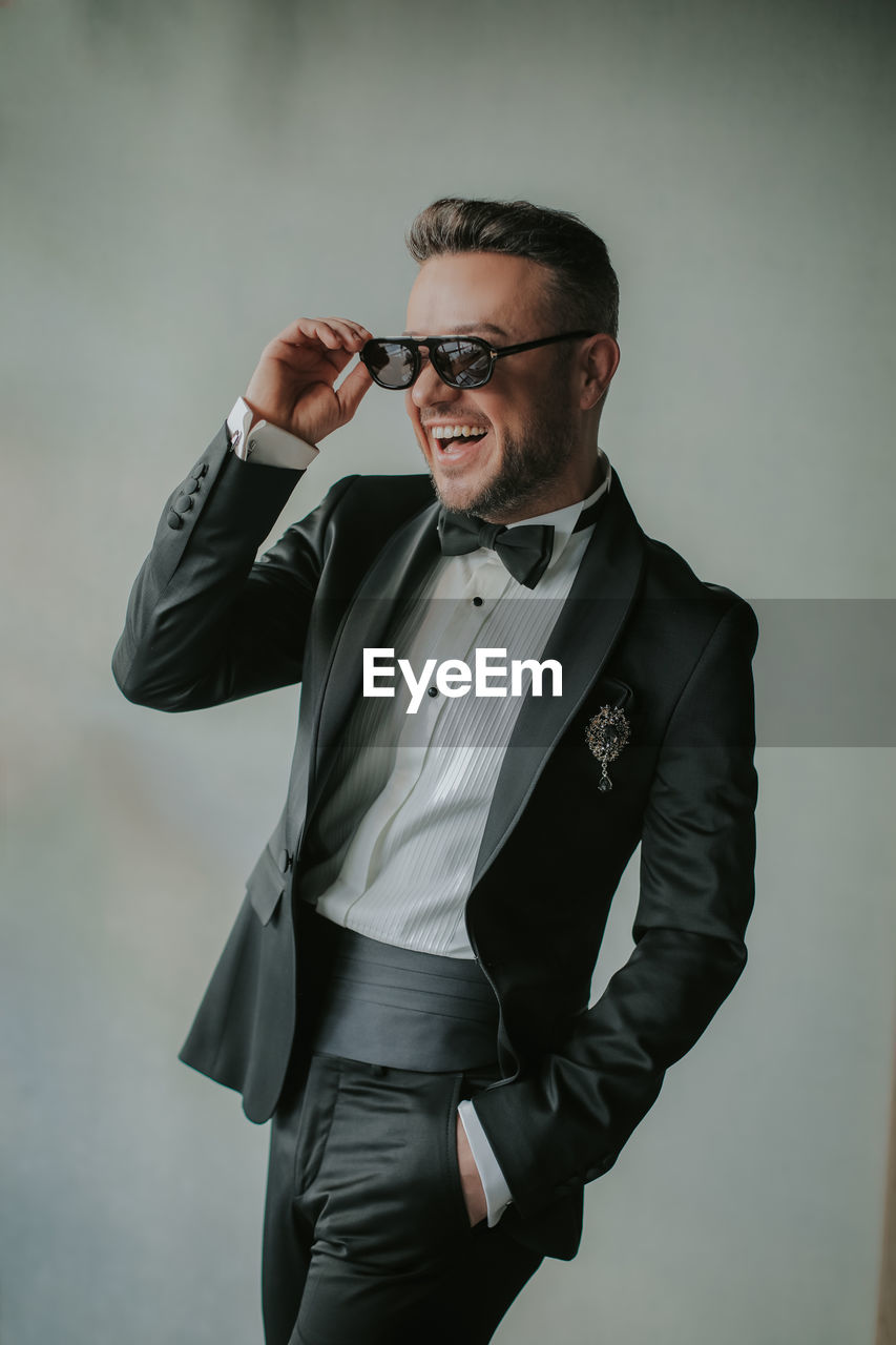 YOUNG MAN LOOKING AWAY WHILE STANDING ON CAMERA