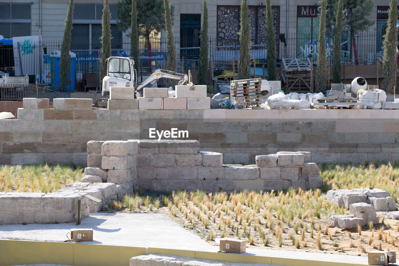 STACK OF STONES ON FIELD AGAINST BUILDINGS