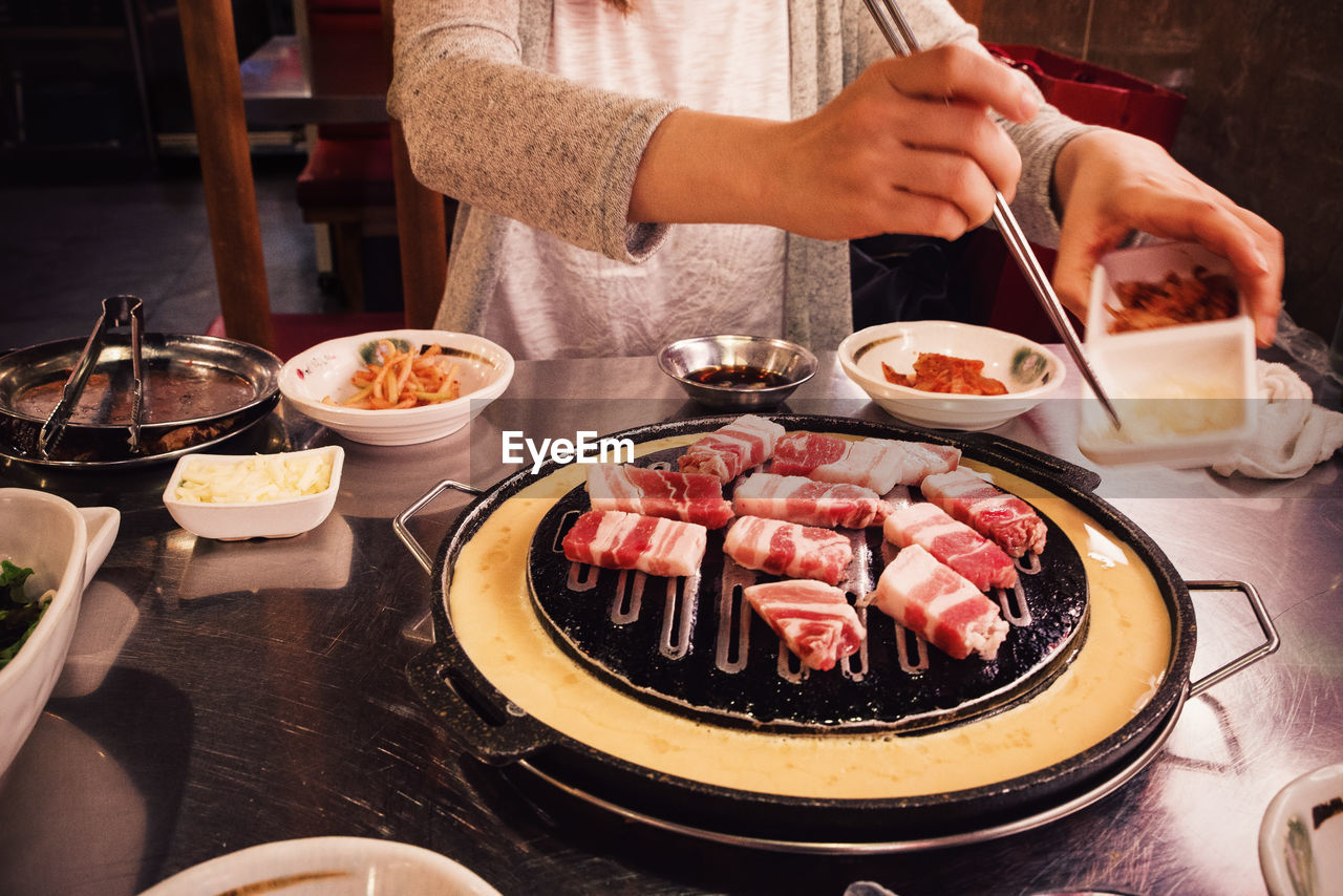 Midsection of woman preparing food in kitchen