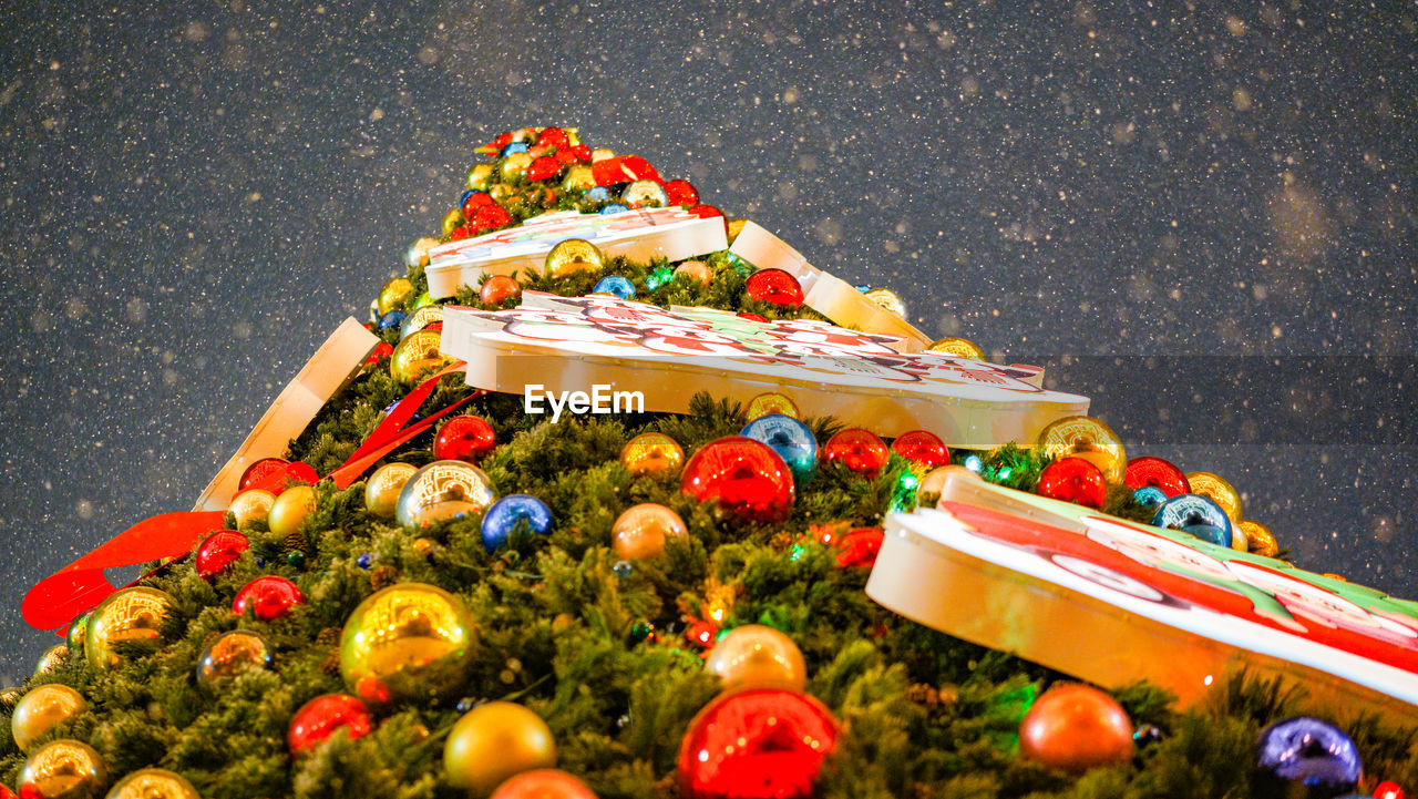 HIGH ANGLE VIEW OF CHRISTMAS DECORATIONS ON TREE AT NIGHT