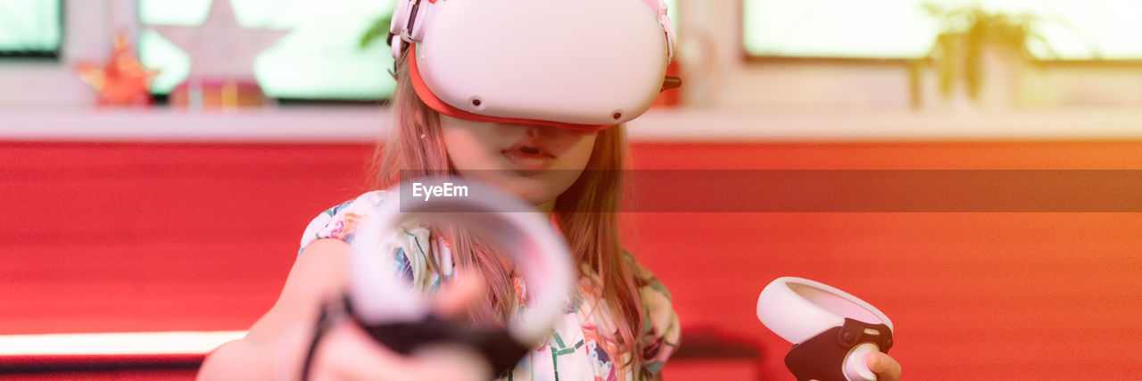 Vr game virtual reality. kid girl gamer playing on futuristic simulation video game in 3d glasses
